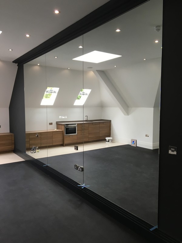 Frameless glass partition in loft conversion by Palmers Green glaziers