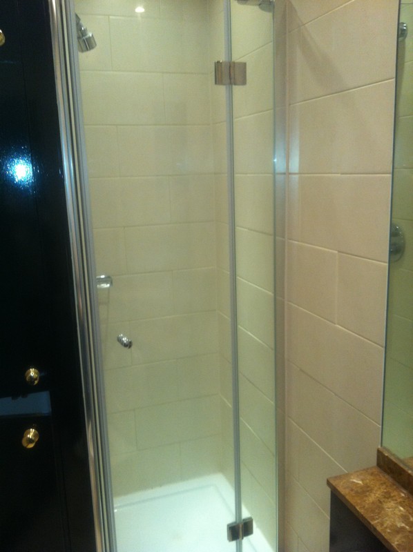 Frameless glass shower enclosure with chrome fittings in Palmers Green