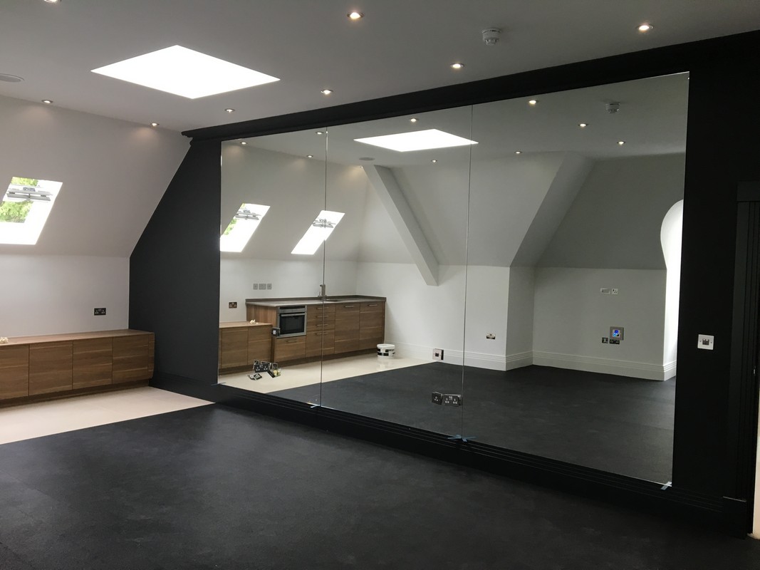 Frameless glass wall dividing loft conversion in Palmers Green